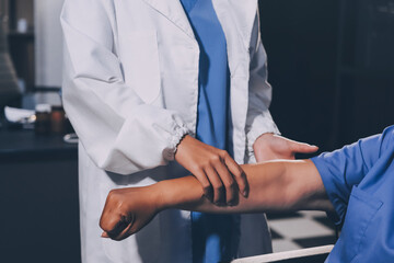 Doctor or Physiotherapist working examining treating injured arm of athlete male patient, stretching and exercise, Doing the Rehabilitation therapy pain in clinic.