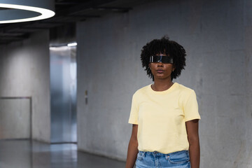 Young woman wearing futuristic visor in modern building is using virtual reality technology