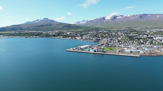 Coastal port city with snowy mountains in backgraound aerial