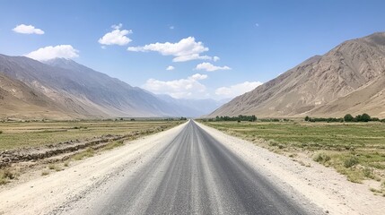 A long stretch of road transitioning from smooth asphalt into rough gravel, leading through a remote, mountainous region