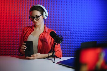 A young blogger girl is recording a video and unboxing her new phone