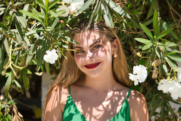 Portrait of a young, beautiful, blue-eyed, blonde woman in a green dress, sweet and tender,...