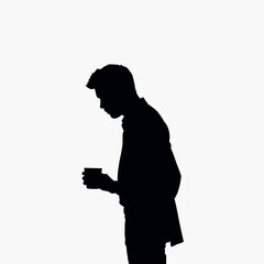 A businessman silhouette standing and drinking coffee, with one hand holding a coffee cup near his mouth