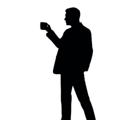 A businessman silhouette standing and drinking coffee, with one hand holding a coffee cup near his mouth