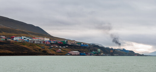 Barentsburg in Svalbard during a cloudy day with visible industrial activity along the coast