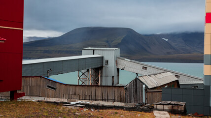 Naklejka premium Unique architecture and landscape of Barentsburg showing industrial structures by the water