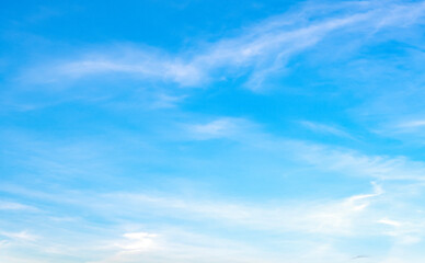 the sky is clear blue with fluffy white clouds, the sky is very bright, and the sun shines.