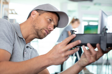 Fototapeta premium man technician repairing a printer at business place at work