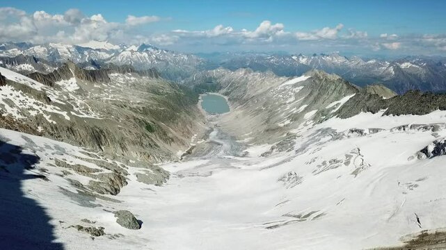 Drone shot of large white snowy glacier surface Oberaar glacier surrounded by mountain peaks, near Grimsel Pass in a beautiful winter day, Oberhaarhorn Gletscher, Switzerland