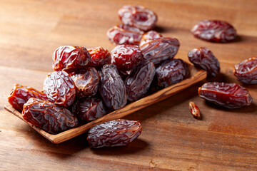 Dates in wooden dish on a old wooden table.