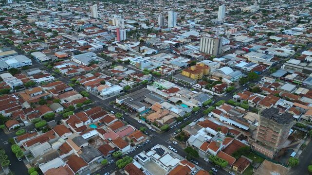 aerial view going forward of a small city in development - Cars passing by the streets and a building construction. Dracena, State of Sao Paulo, Brazil