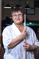 An elderly woman in a billiard club.