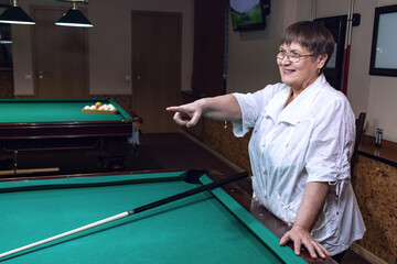 An elderly woman in a billiard club.