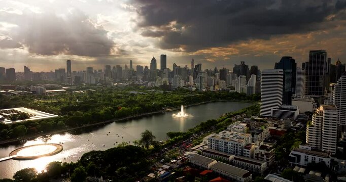 Benchakitti Forest Park with lake in downtown Bangkok, drone skyline sunset view
