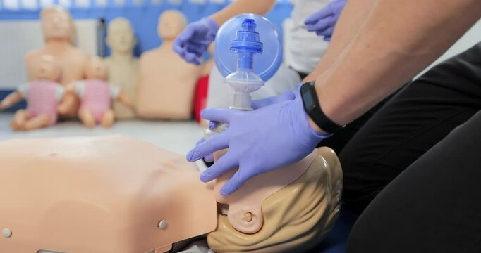 CPR training using and an AED and bag mask valve on an adult training manikin.