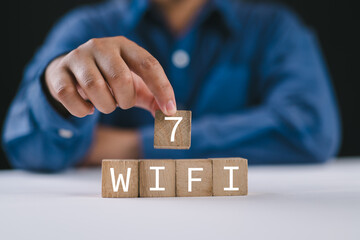 WiFi 7 CERTIFIED. Hand hold wooden cube blocks with WiFi-7 symbol. Transformation technology and upgrade router for high internet speed to support IoT and smartphones. Enhances network performance.