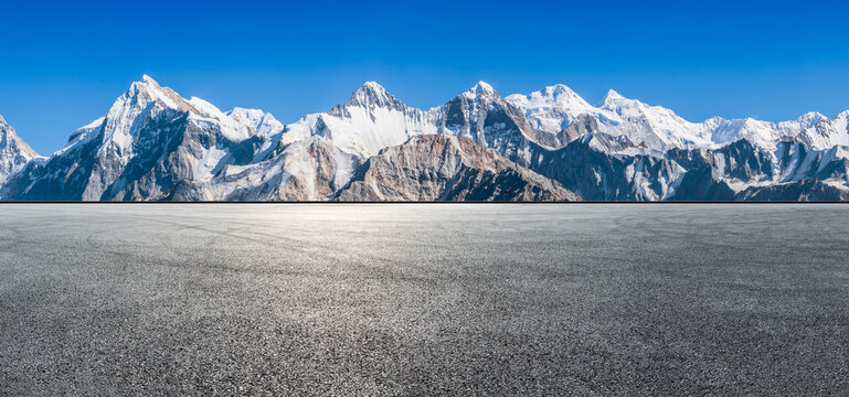 Asphalt road square and snow mountain natural landscape under blue sky. car background.