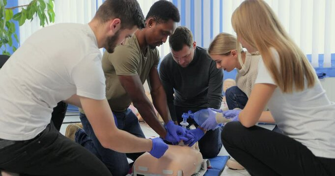 Closeup of students practicing CPR chest compression on dummy.