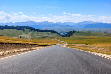 Country road and grassland with mountain nature background. Road trip.