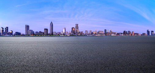 Asphalt road square and city skyline with modern buildings scenery at dusk in Shanghai. car advertising background.