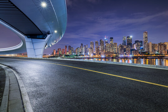 Fototapeta Asphalt road and bridge with modern city buildings at night in Chongqing. car background.