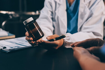 Senior woman holding medicine bottle with nurse using laptop at home