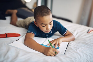 Young, boy or writing with book for alphabet, creativity or literature for educational activity on bed at home. Teenager, male person or child with pencil for letter, character or homework in bedroom