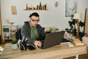 A young man with Down syndrome engages with his laptop at home.