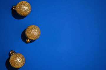 Golden Christmas ornaments on a blue background. New Year card.