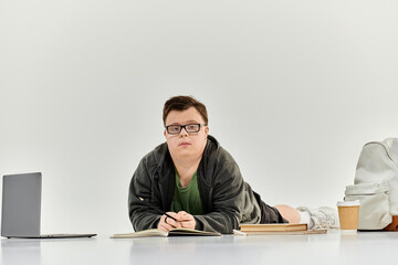 A young man with Down syndrome studies with focus in a cozy home environment.