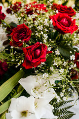 A bouquet of red roses and white flowers that serve as a wedding decoration