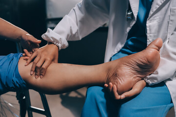 Physiotherapist nurse doing physiotherapy to rehabilitate leg of elderly female patient.