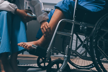 Fototapeta premium Physiotherapist nurse doing physiotherapy to rehabilitate leg of elderly female patient.