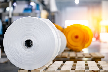 Rollers of polyethylene bags in Warehouse of production of plastic packaging, sunlight.