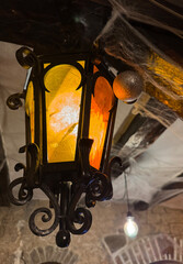 An old forged lantern, covered in cobwebs, glows with a dim light, creating a mystical atmosphere...