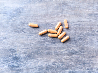 Lutein capsules. Dietary supplement on wooden background. Soft focus. Top view. Close up. Copy...