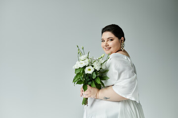 A radiant bride embraces her beauty, wearing a flowing white gown and holding a lush bouquet of flowers.