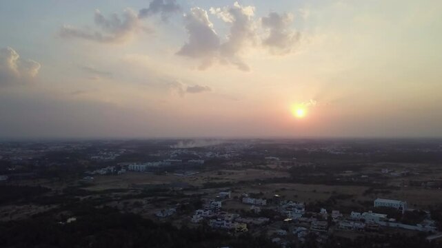 High angle shot of sunset in Tamil Nadu with a cityscape of Tiruppur at evening. Aerial.