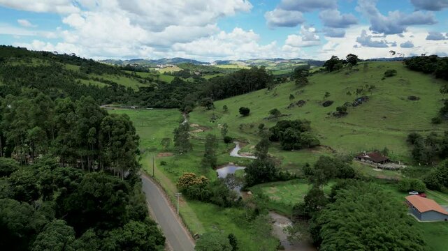 aerial reverse dolly view of a road that connects other city to Bueno Brandao, an agricultural town with green hills, coffee plantations, waterfalls, motocross trails and vacation destination . Brazil