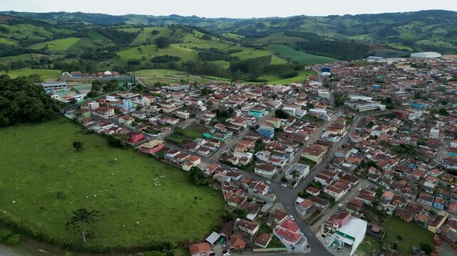 Real state Brazil - Aerial view of a small town surrounded by mountains and green fields in Brazil - Bueno Brandao, Minas Gerais