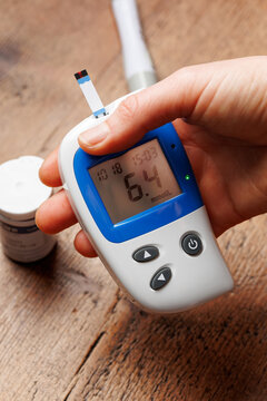 Person using glucometer, checking blood sugar level. Diabetes concept