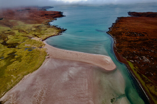 Aerial view of serene west coast beach scene with rugged coastline and majestic ocean, Ullapool, Scotland.