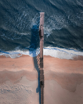 Aerial view of beautiful beach with serene ocean waves and a tranquil pier, Belmar, United States.