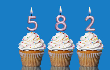 Birthday Cupcakes With Candles Lit Forming The Number 582