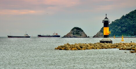 Lighthouse, vessels and breakwaters in Songdo beach, Busan, South Korea.