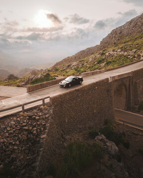 Aerial view of winding road and car amidst majestic mountains and beautiful landscape at Sa Calobra, Nus de Sa Corbata, Escorca, Spain.