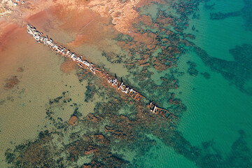 Aerial view of Beadon Bay at sunset with Onslow old salt loading jetty and serene coastline, Onslow, Australia.