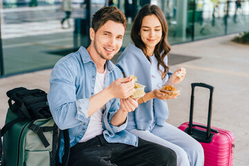 Caucasian man and woman casually dressed engaged in conversation. Couple travelers with luggage...