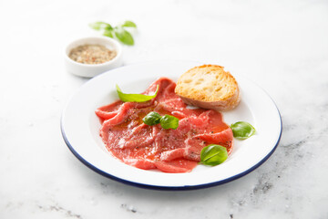 Traditional beef carpaccio with salt and pepper