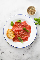 Traditional beef carpaccio with salt and pepper